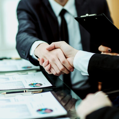 closeup of handshake of business partners after discussion of the financial agreement on the background of the workplace