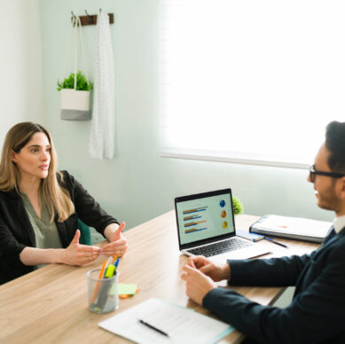 Attractive business professional talking about a work deal and analytic report with her male boss. Female colleague having a meeting with her coworker at the office